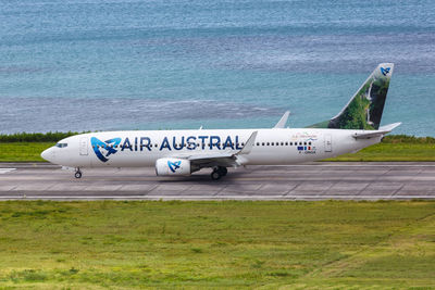 Side view of airplane on airport runway against sky