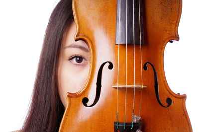 Portrait of young woman with violin against white background