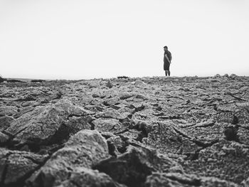 Rear view of woman walking on landscape against clear sky