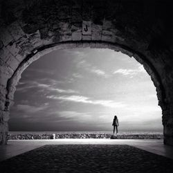 Silhouette of woman standing against cloudy sky