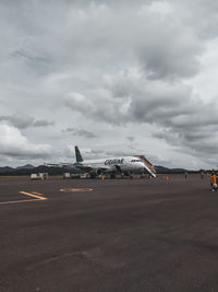 Airplane on runway against sky