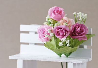 Close-up of pink rose on white table