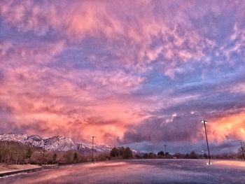 Road passing through landscape against cloudy sky