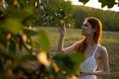 Young woman standing by plants