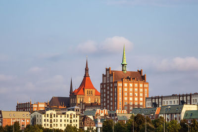 Buildings in city against cloudy sky