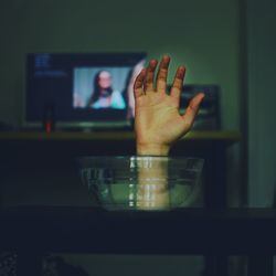 Close-up of hand reaching out from bowl