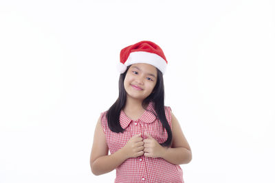 Portrait of smiling girl standing against white background