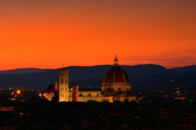 Illuminated buildings against sky during sunset