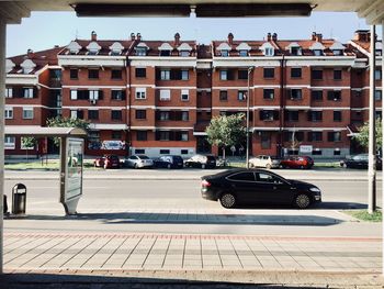 Cars on road by buildings in city