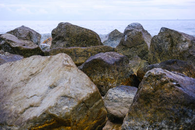 Rocks on sea shore against sky