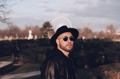 Portrait of man wearing sunglasses standing against sky