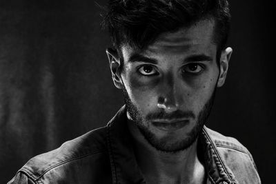 Close-up portrait of young man in darkroom