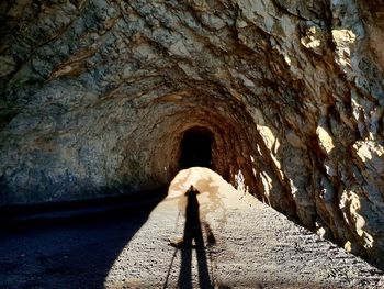 Shadow of person on rock in tunnel