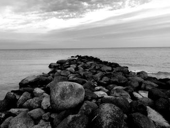 Rocks on sea shore against sky