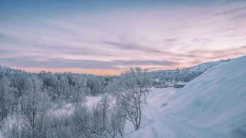 Scenic view of snowcapped mountains against sky during sunset