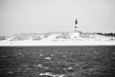 Scenic view of sea and snowcapped mountain against sky