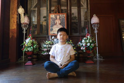 Portrait of boy meditate on floor