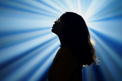 Young woman standing against light beams