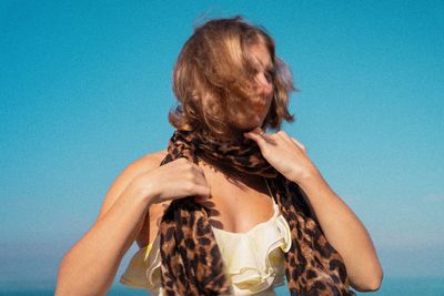 Low angle view of woman against blue sky