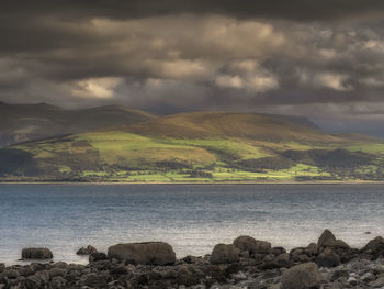 Scenic view of sea and mountains against sky