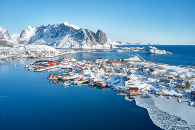 Aerial view of sea and mountains against clear blue sky