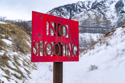 Close-up of sign on snow covered plant