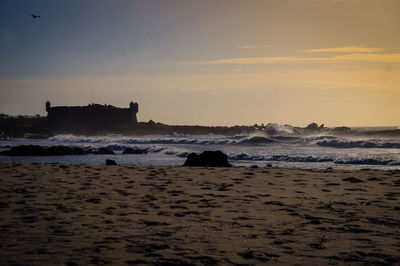 Scenic view of beach against sky during sunset