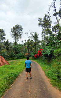 Rear view of woman walking on road