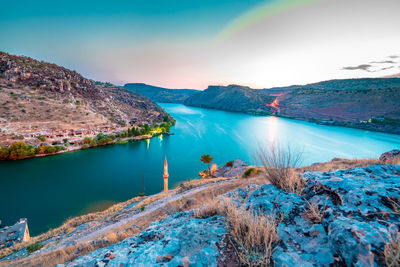 Scenic view of lake by mountains against sky