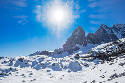 Scenic view of snowcapped mountains against blue sky