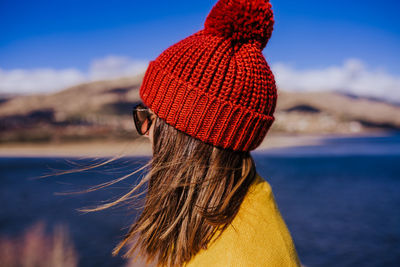 Woman looking away against lake during winter