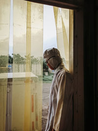 Side view of man looking at window