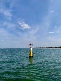 Lighthouse by sea against sky