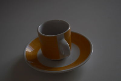 Close-up of coffee cup on table against black background