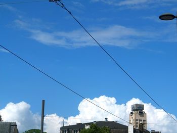 Low angle view of power lines against blue sky