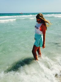 Young woman standing in sea at beach