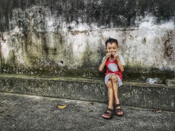 Portrait of smiling girl sitting outdoors