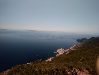 Scenic view of sea and mountains against clear sky