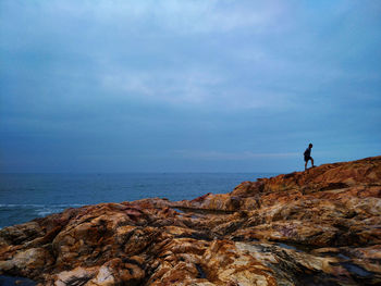 Man by sea on rock