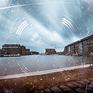 Buildings against sky seen through glass window