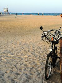 Bicycle on beach against sky