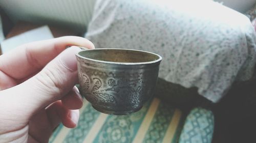 Close-up of hand holding coffee cup