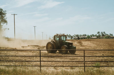 Tractor on grassy field against sky