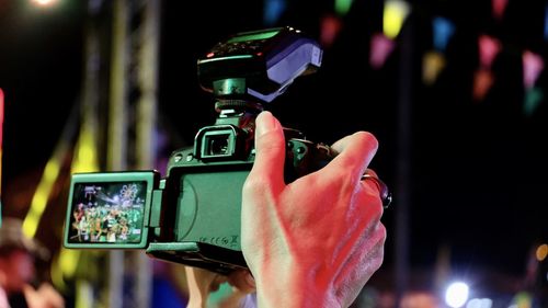 Cropped hand of person photographing at night