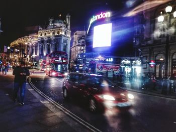 People on illuminated street at night