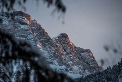 Close-up of frozen rock against sky during winter