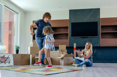 Full length of father and daughter on floor at home