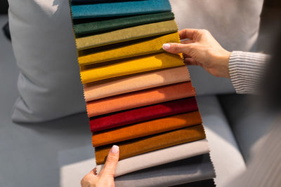 The woman chooses the fabric on the sofa. a young women looks at tissue samples.