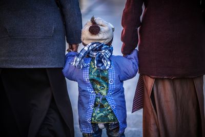 Rear view of family in warm clothing walking on footpath