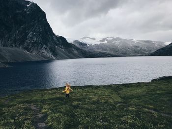 Rear view of man in lake against sky